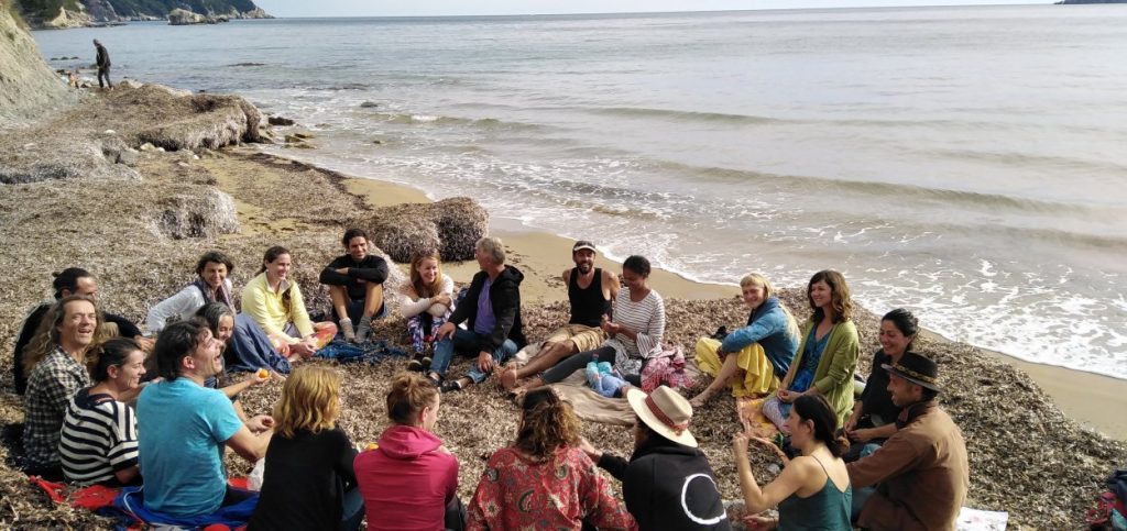 Image of people in a circle on the beach